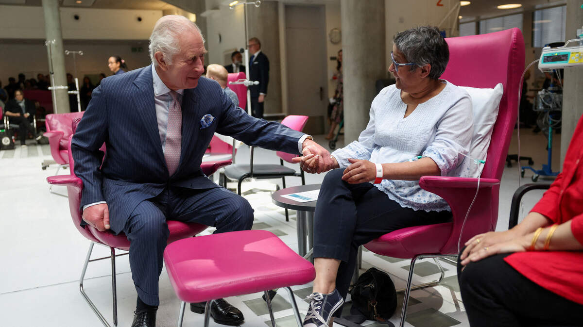 El rey Carlos III conversa con la paciente Asha Millan en el Centro de Cáncer del Hospital Universitario Macmillan, en Londres, el martes 30 de abril de 2024.