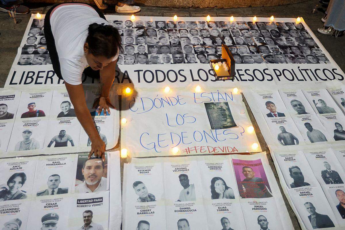 Una mujer arregla algunos carteles durante una vigilia para exigir la liberación de todos los presos políticos, cerca de El Helicoide, una de las principales cárceles del régimen chavista, el sábado 17 de enero de 2026, en Caracas, Venezuela.