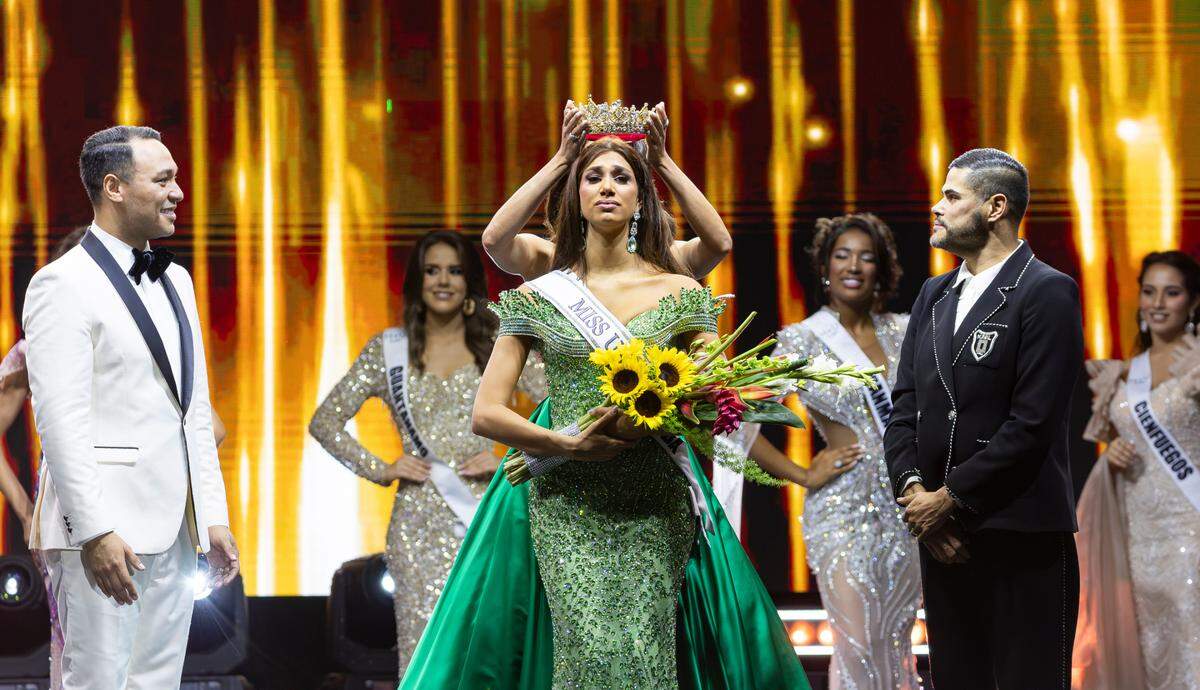 Lina Luaces, center, representing Santiago de Cuba, is crowned by Marianela Ancheta after winning the Miss Universe Cuba 2025 beauty pageant at Milander Park on Tuesday, July 8, 2025, in Hialeah, Fla.