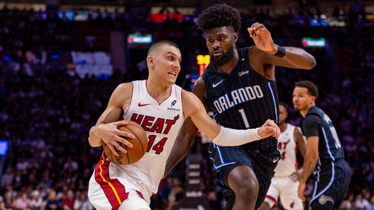 El jugador del Heat Tyler Herro (izq.) entra al aro ante la marca de Jonathan Isaacs, del Magic de Orlando, en el partido de la NBA celebrado el 23 de octubre de 2024 en Miami.