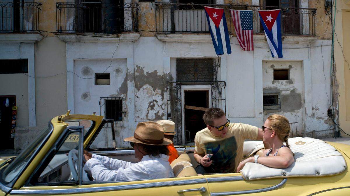 Foto de archivo de turistas paseando en un auto clásico en La Habana, Cuba.