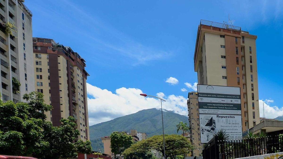Decenas de personas hacen fila para entrar a un supermercado en Caracas, el jueves 13 de julio. 
