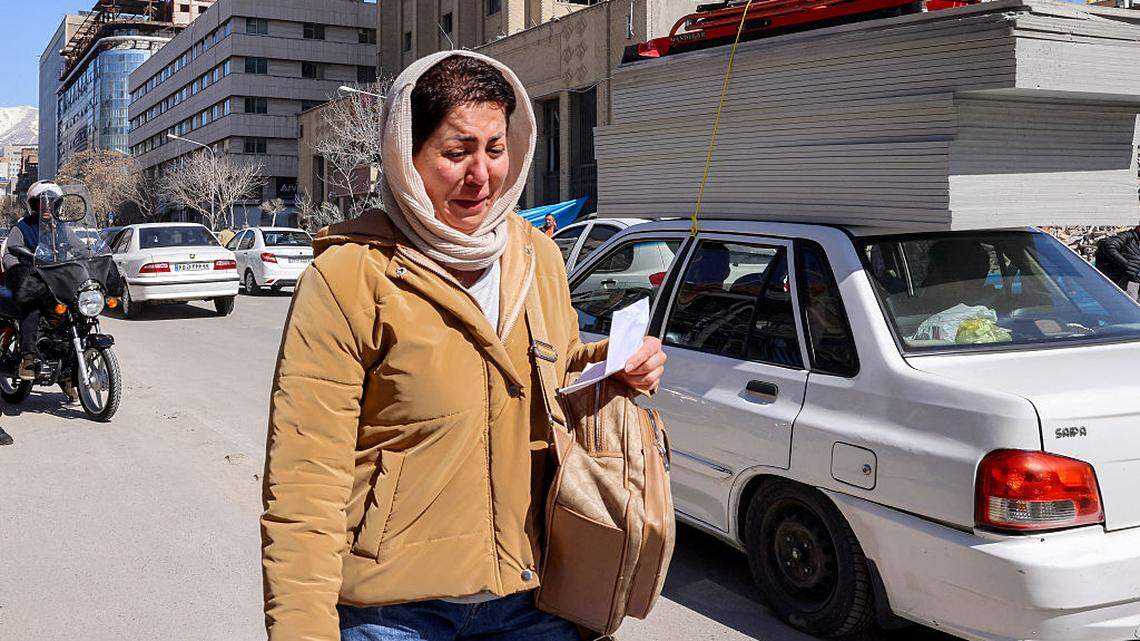 Una mujer reacciona mientras camina junto a edificios derrumbados y dañados cerca de la plaza Ferdowsi en Teherán, Irán, el martes 3 de marzo de 2026.