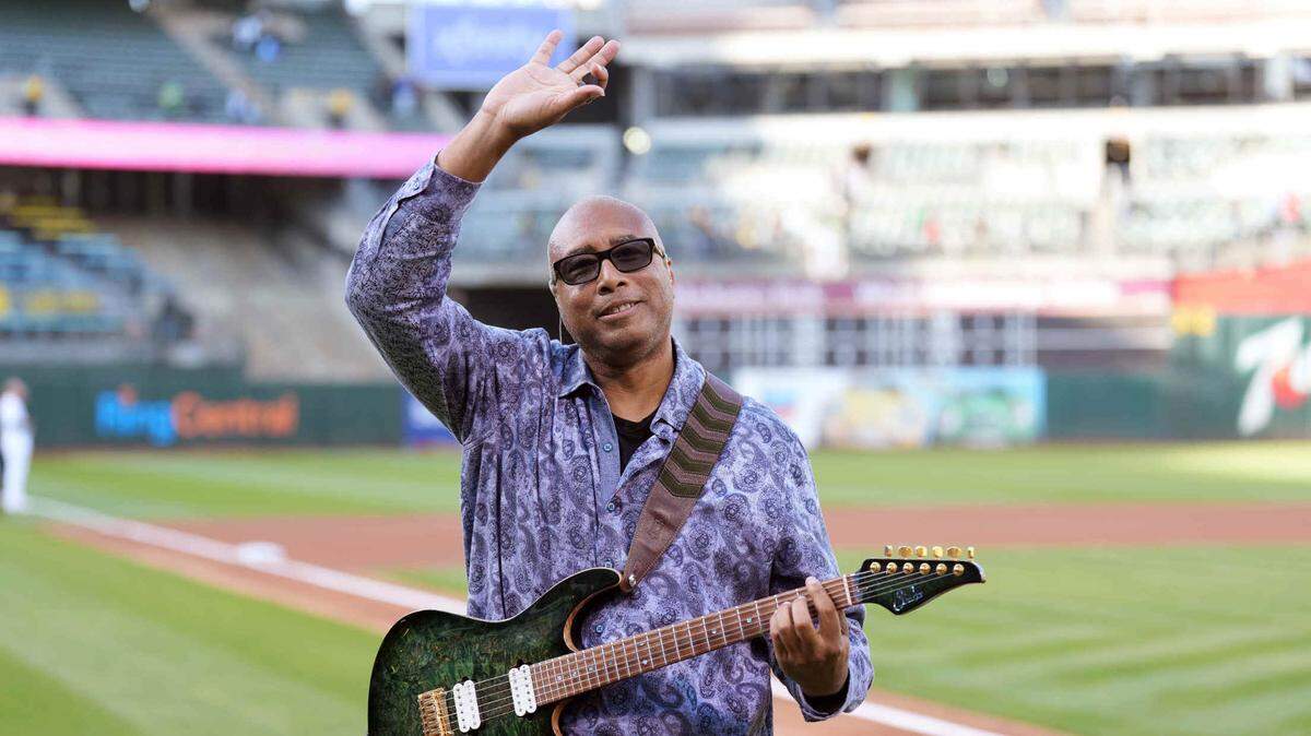 El exjugador de los Yankees de Nueva York, Bernie Williams, saluda después de interpretar el Himno Nacional de Estados Unidos antes del partido entre los Atléticos y los Mellizos de Minnesota, el 16 de mayo de 2022 en Oakland, California.