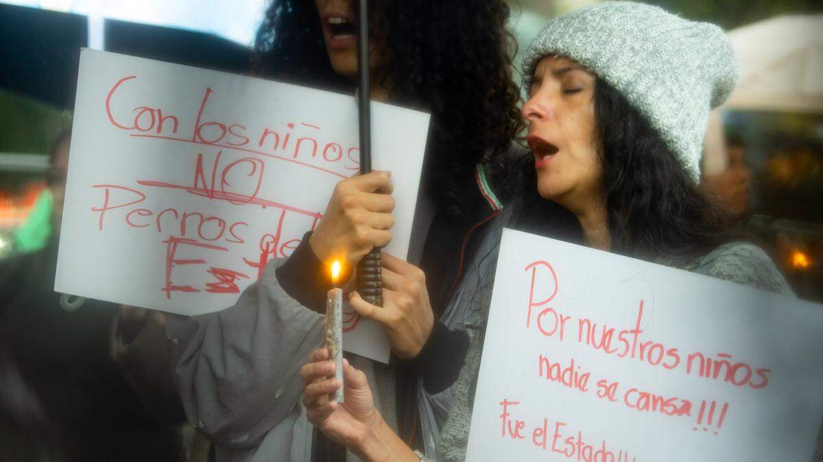 Una mujer sostiene una vela y una pancarta en protesta para exigir el retorno de cuatro menores de edad que desaparecieron el 8 de diciembre tras ser detenidos por una unidad militar, en Quito, Ecuador, el lunes 30 de diciembre de 2024.