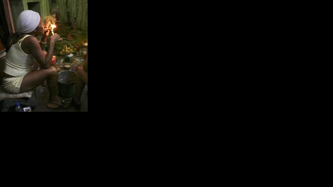 Una sacerdotiza santera fuma un tabaco durante una ceremonia del culto afrocubano que está ganando adeptos en Venezuela.