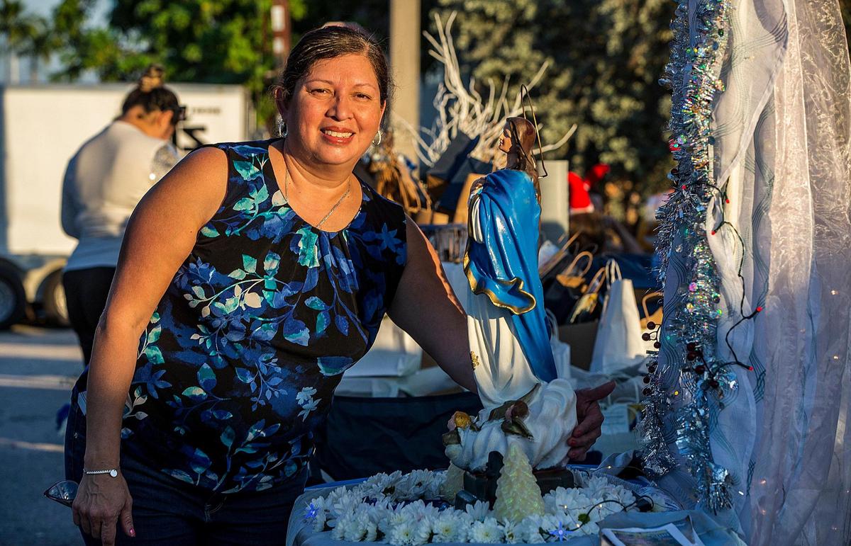 Sheyla Urbina posa junto a una figura de la Virgen María, que heredó de su madre, durante la celebración de La Gritería, celebración religiosa popular en honor a la Inmaculada Concepción de la Virgen María en Nicaragua, el sábado 10 de diciembre de 2022.