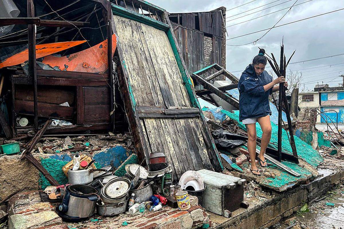 Una mujer rescata pertenencias de entre los escombros de su casa tras el derrumbe provocado por el huracán Melissa a su paso por Santiago de Cuba, el 29 de octubre de 2025. 