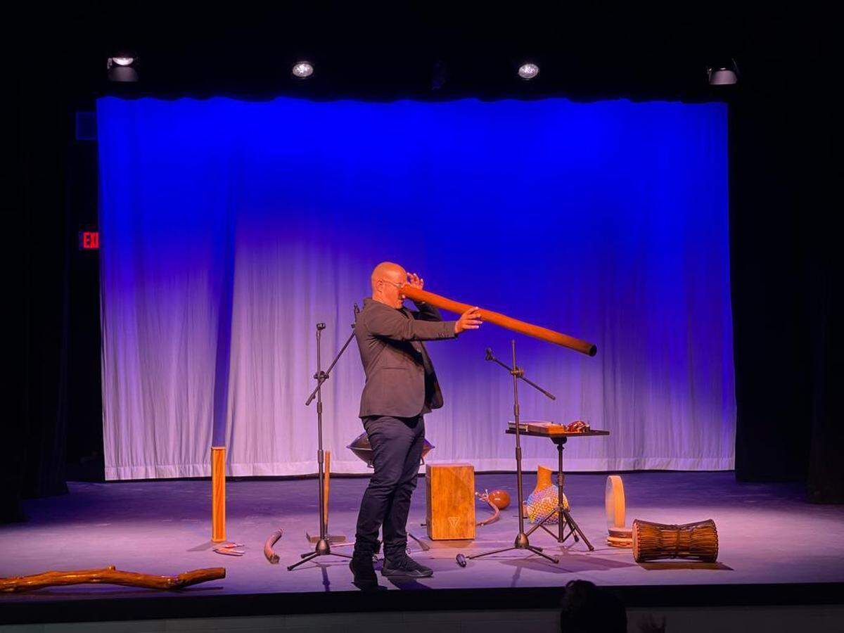 Michael Gil presentando una serie de instrumentos ancestrales en escena.