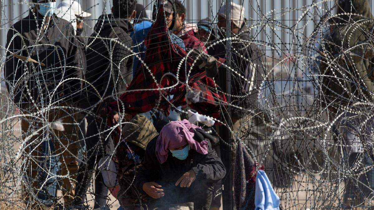 Agentes de la Guardia Nacional de Texas devuelven a un grupo de inmigrantes que intentaron cruzar la cerca de alambres de púas para entregarse a la Patrulla Fronteriza, en el Río Grande, en El Paso, el jueves 21 de marzo de 2024.