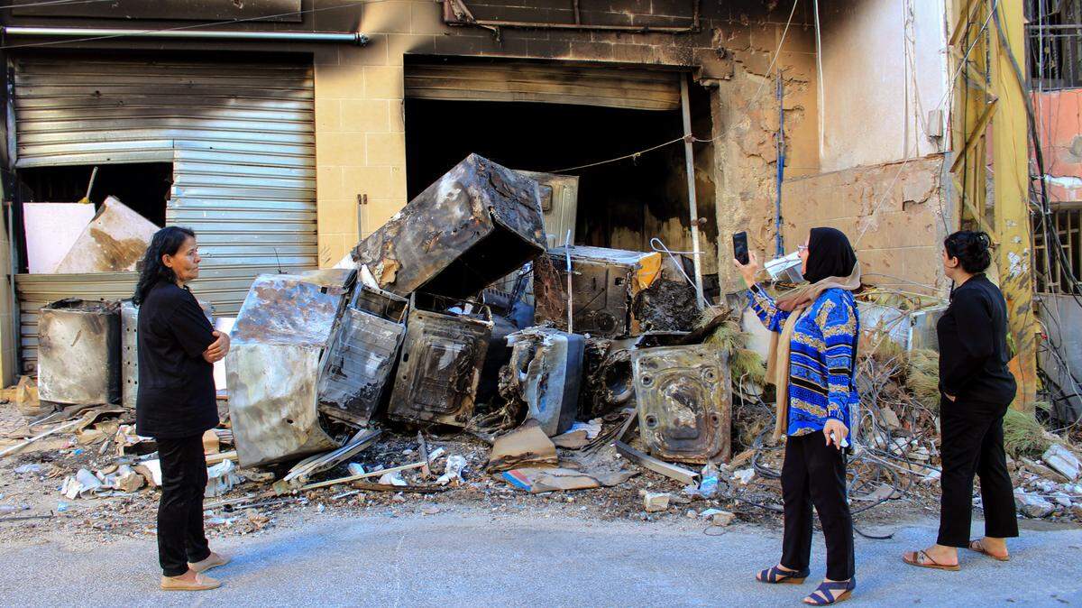 Tres mujeres inspeccionan un edificio destruido por un bombardeo israelí en el pueblo de Khiam, en el sur de Líbano, durante un enfrentamiento con las milicias pro-iraníes Hezbolá, el 26 de agosto de 2024.