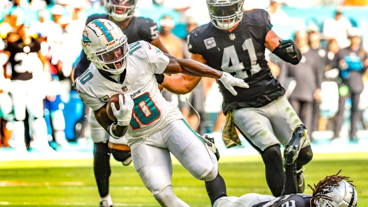 Miami Dolphins wide receiver Tyreek Hill (10) breaks a tackle by Las Vegas Raiders safety Tre’von Moehrig (25) to score in the first half at Hard Rock Stadium in Miami Gardens on Sunday, November 19, 2023.