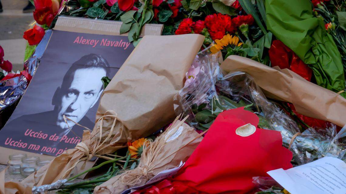 Flowers placed in honor of the late Russian opposition leader Alexei Navalny surround his portrait in a square in Rome, Italy, Monday, February 19, 2024.