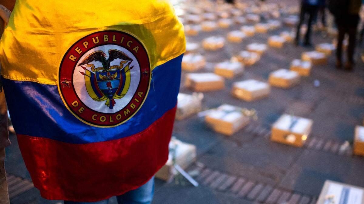 Una persona con una bandera de Colombia participa en una protesta en contra de los asesinatos y ataques terroristas, en la Plaza de Bolívar, Bogotá, el 20 de febrero de 2024. 