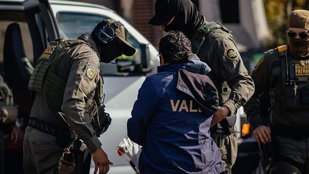 CHICAGO, ILLINOIS - OCTOBER 31: U.S. federal agents detain a man during an immigration raid in a residential neighborhood on the far north side of the city on October 31, 2025, in Chicago, Illinois. The operation was carried out as part of President Donald Trump's administration's "Operation Midway Blitz," an ongoing immigration enforcement surge across the Chicago region. (Photo by Jamie Kelter Davis/Getty Images)