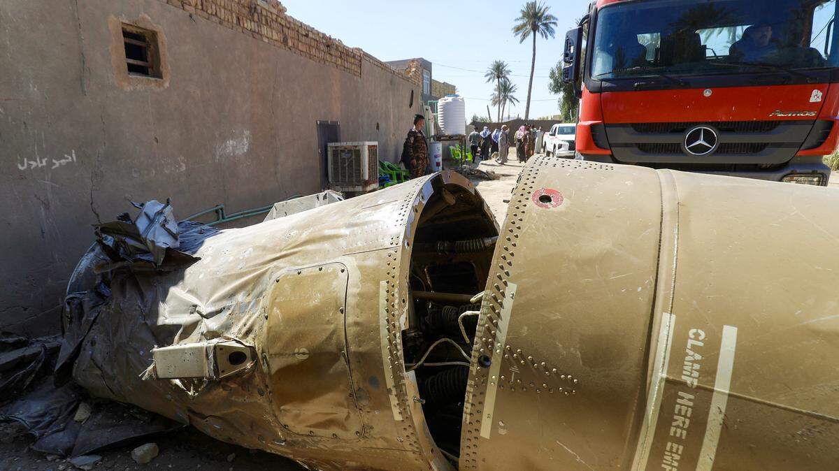 Miembros de defensa civil y fuerzas de seguridad inspeccionan el cuerpo de un misil no identificado que cayó en una zona rural cerca de la ciudad de Al-Qasim, en el sur de la provincia central de Babilonia, en Irak, el 9 de marzo de 2026.