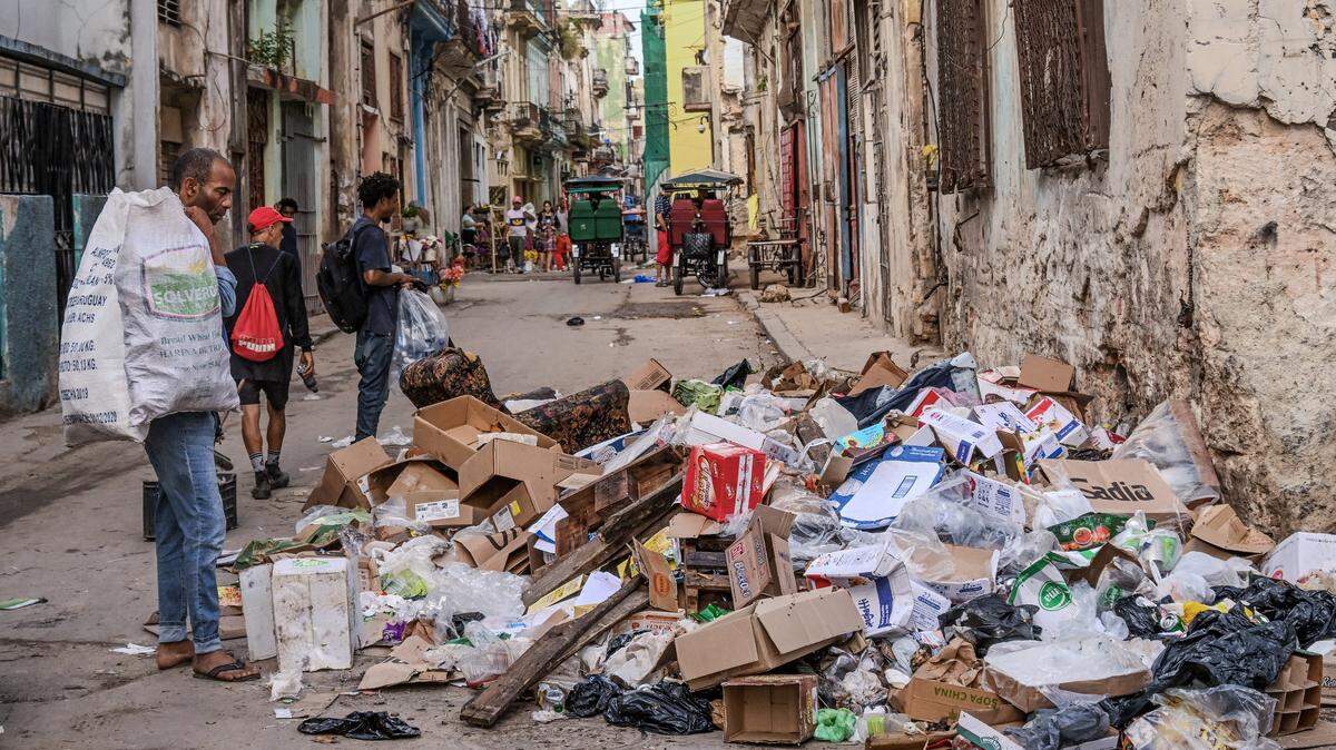 Personas caminan junto a basura abandonada en una calle de La Habana el 23 de enero de 2026.