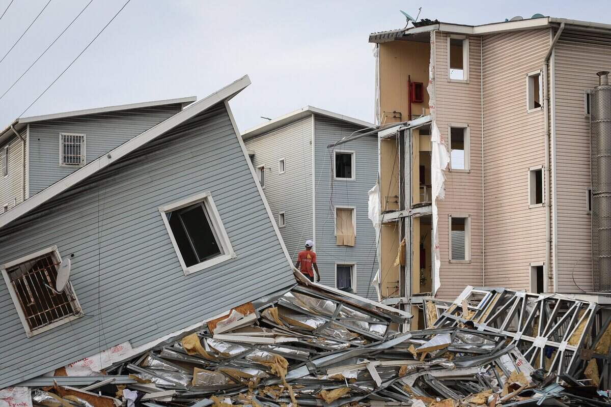Personas buscan sus pertenencias entre los escombros de edificios colapsados en el complejo habitacional Urbanismo Hugo Chávez, tras un terremoto de magnitud 7.2 que sacudió Venezuela y otras regiones del Caribe el 30 de junio de 2026 en Caracas, Venezuela.