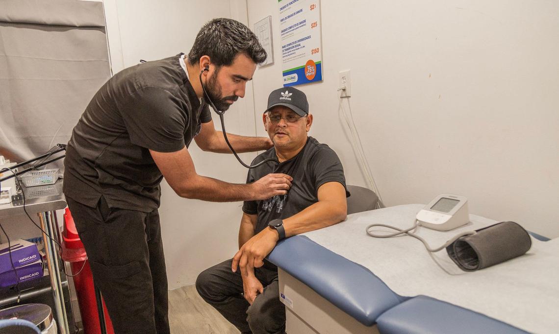 Ricardo Paneque, graduado de medicina en Cuba y enfermero practicante en Miami, atiende a Eusebio Domínguez en Dr. GoodPrice. La clínica y farmacia ofrece consultas y pruebas médicas a precios módicos en La Pequeña Habana.