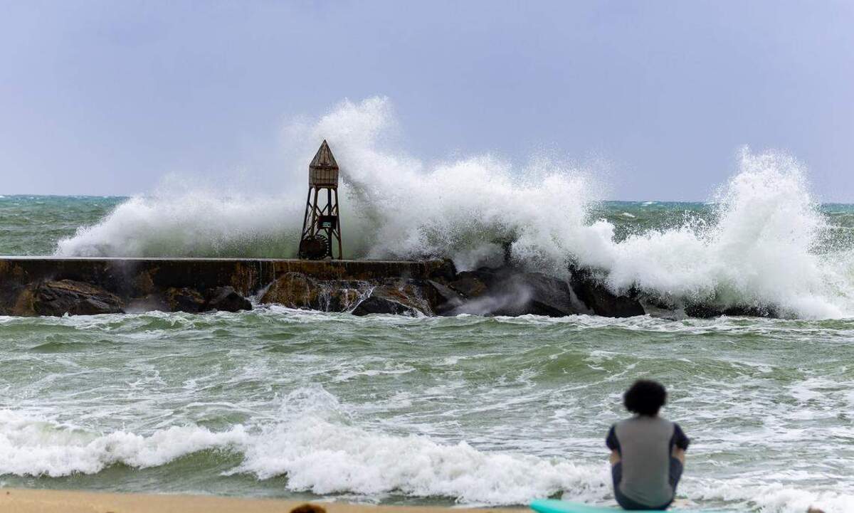 Un surfista observa cómo las olas se estrellan contra el espigón del faro de Bal Harbour el 5 de noviembre de 2024. Este fue un periodo de riesgo elevado de corrientes de resaca. David Santiago dsantiago@miamiherald.com