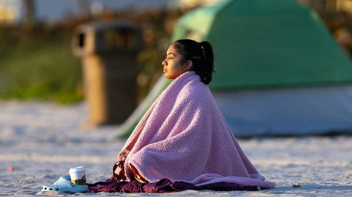 South Florida’s Lorraine Rodriguez bundled for a cold sunrise in Sunny Isles Beach last year on Jan. 30, 2024. People like her may find temperatures in the low 50s the first full week of January 2025, a year later.