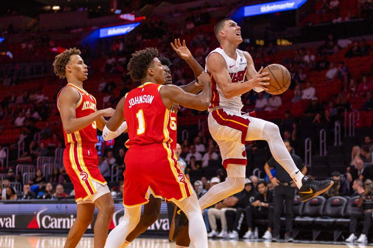 El jugador del Heat Tyler Herro entra al aro ante la marca de Clint Capela (15) y Jalen Johnson, de los Hawks de Atlanta, en el partido de pretemporada celebrado el 16 de octubre de 2024 en Miami.