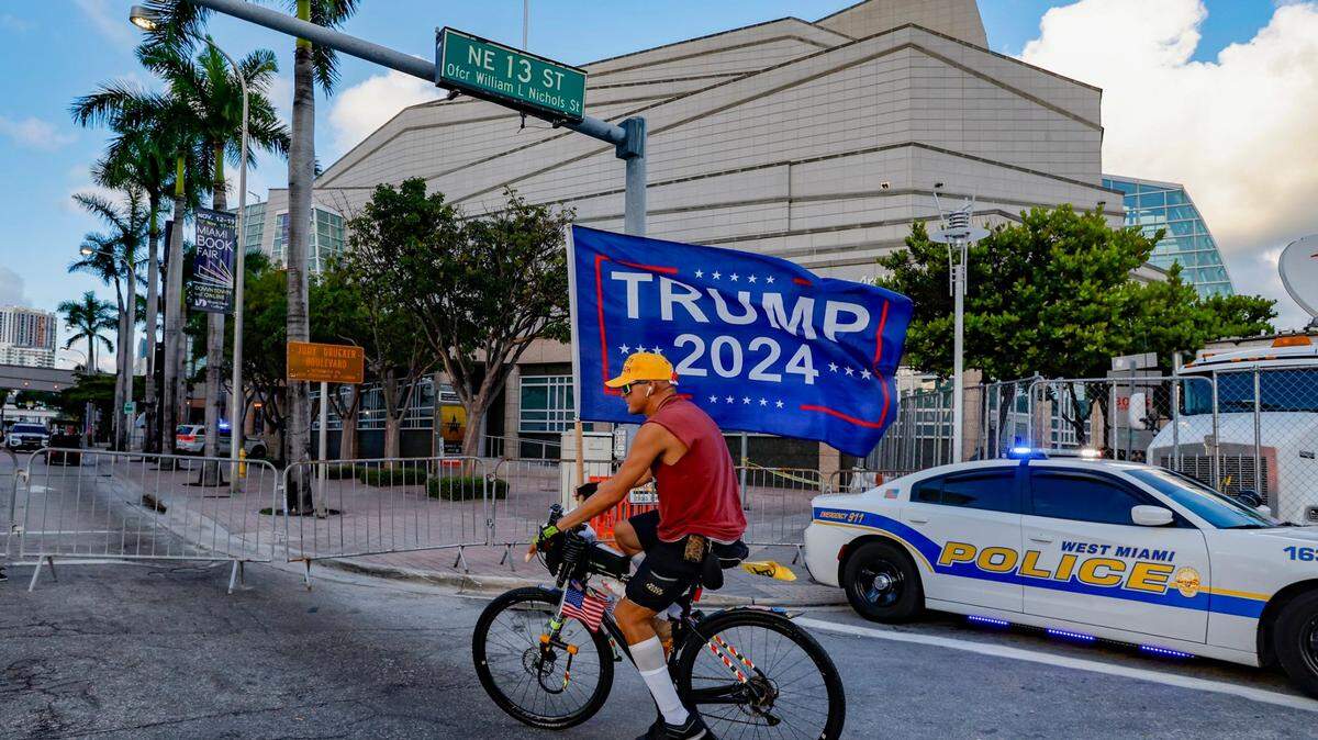 Chaunce O’Connor, de 41 años, carga una bandera en apoyo del expresidente Donald Trump frente al Centro Adrienne Arsht de las Artes Escénicas, en downtown Miami, el miércoles 8 de noviembre de 2023.