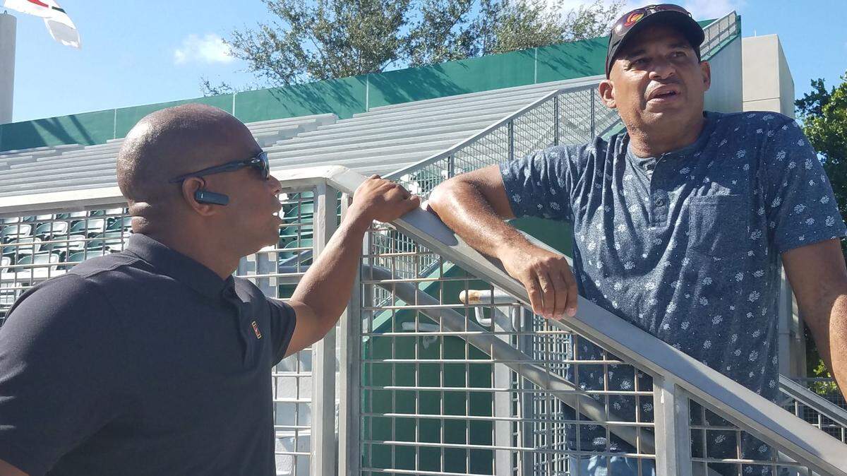 Orestes Kindelán (der.) conversa con Orlando “El Duque’’ Hernández en el estadio de la Universidad de Miami, el 9 de noviembre de 2018.