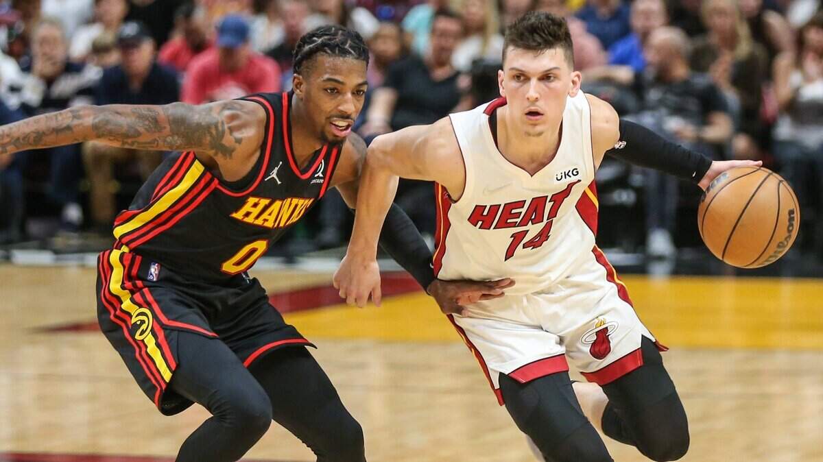 El escolta de los Miami Heat, Tyler Herro (14), conduce el balón mientras el escolta de los Atlanta Hawks, Delon Wright (0), defiende en el último cuarto en el FTX Arena de Miami, Florida, el viernes 8 de abril de 2022.
