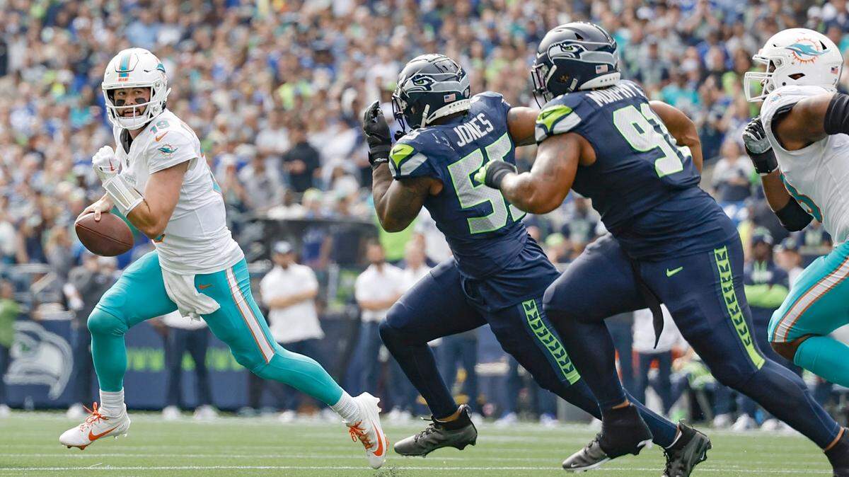 El quarterback de los Dolphins, Skylar Thompson, corre con el ovoide ante la presión de la defensa de los Seahawks, en la primera mitad del partido celebrado el 22 de septiembre de 2024 en el Lumen Field en Seattle, Washington.