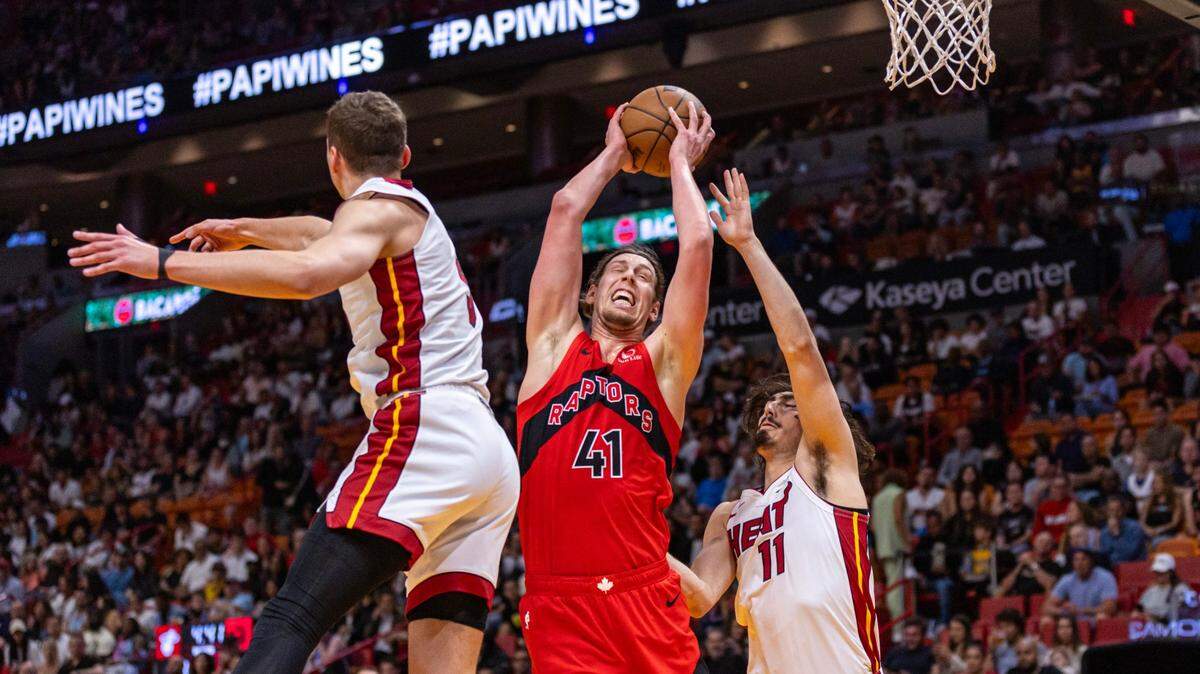 El delantero de los Toronto Raptors Kelly Olynyk (41) recoge el rebote sobre el guardia del Miami Heat Jaime Jaquez Jr. (11) y el delantero Nikola Jokic (50) durante la primera mitad de un partido de la NBA en el Kaseya Center en Miami, Florida, el viernes 12 de abril. 2024.