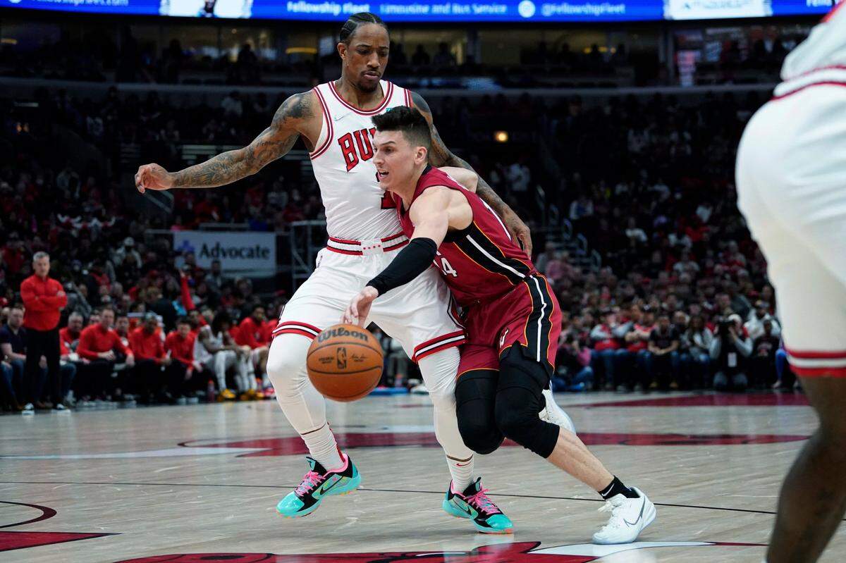 El jugador del Heat Tyler Herro (der.) entra al aro ante la marca de DeMar DeRozan, de los Bulls, en el partido celebrado el 2 de abril de 2022 en Chicago.