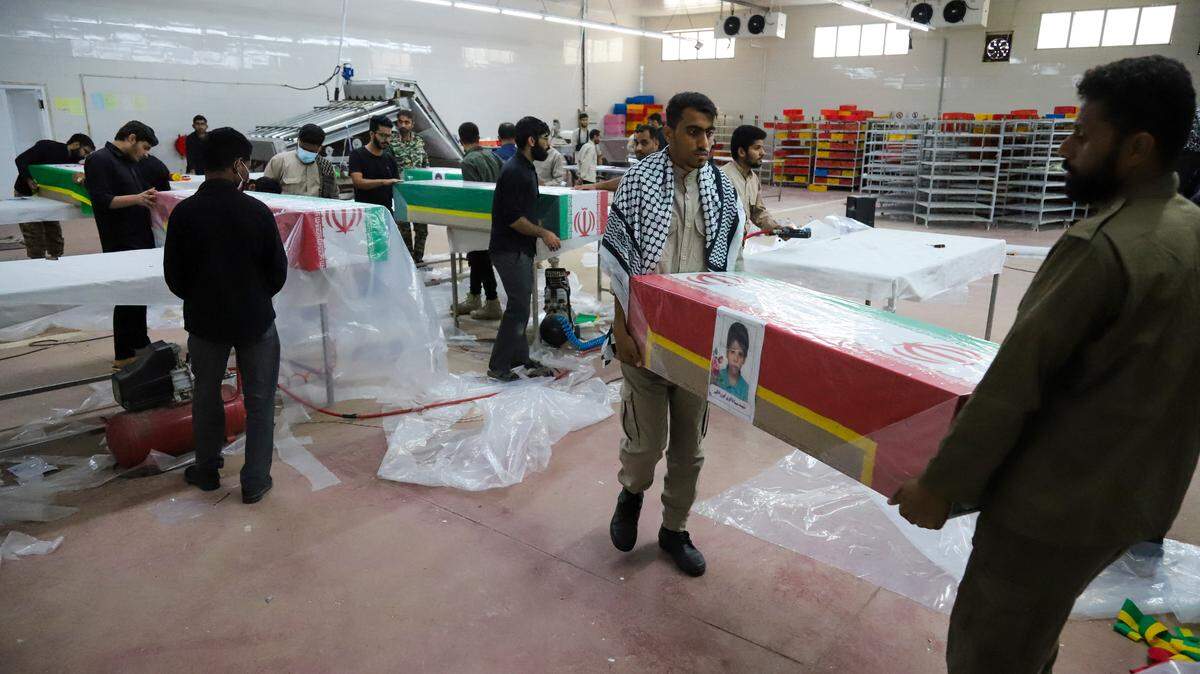 En esta imagen obtenida de la agencia de noticias ISNA de Irán, los dolientes preparan los ataúdes de niños que fueron asesinados en un supuesto ataque a una escuela primaria en la provincia de Hormozgan, Irán, para un funeral en Minab el 3 de marzo de 2026.