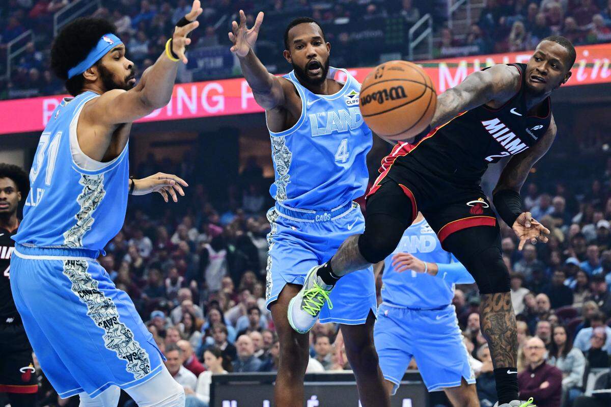 El jugador del Heat de Miam Terry Rozier (der.) pasa la pelota ante la marca de Jarrett Allen (31) y Evan Mobley, de los Cavaliers, en el partido celebrado el 5 de marzo de 2025 en Cleveland.