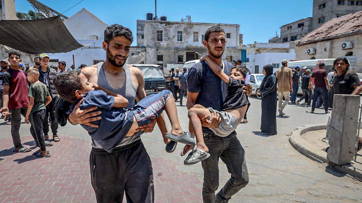 Palestinos llevan a dos niños heridos al Hospital Bautista luego de que una casa, previamente amenazada por Israel y ubicada cerca del hospital en el barrio de Zeitoun, fuera atacada en el este de Ciudad de Gaza el 16 de julio de 2025. 