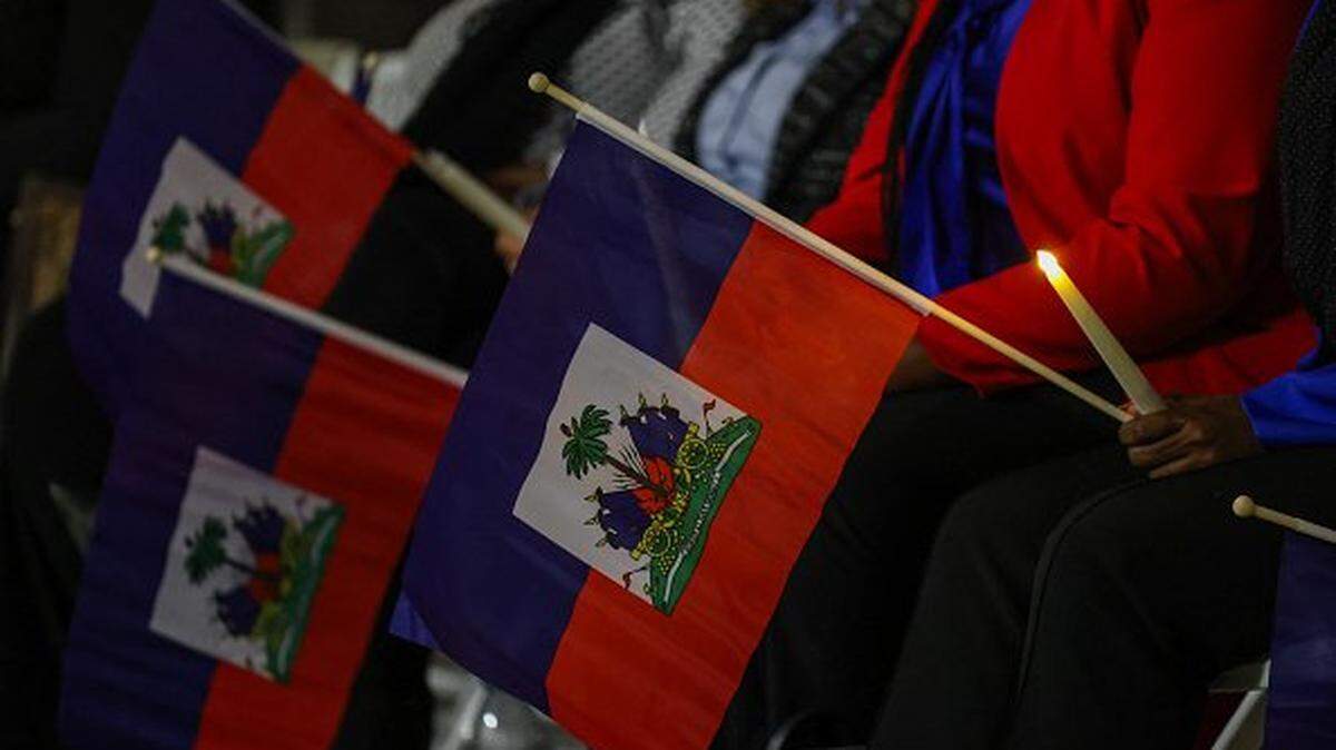 Personas asisten en Miami a una vigilia con velas y banderas en memoria de los haitianos que viven en Estados Unidos bajo la protección del TPS el pasado 3 de febrero.