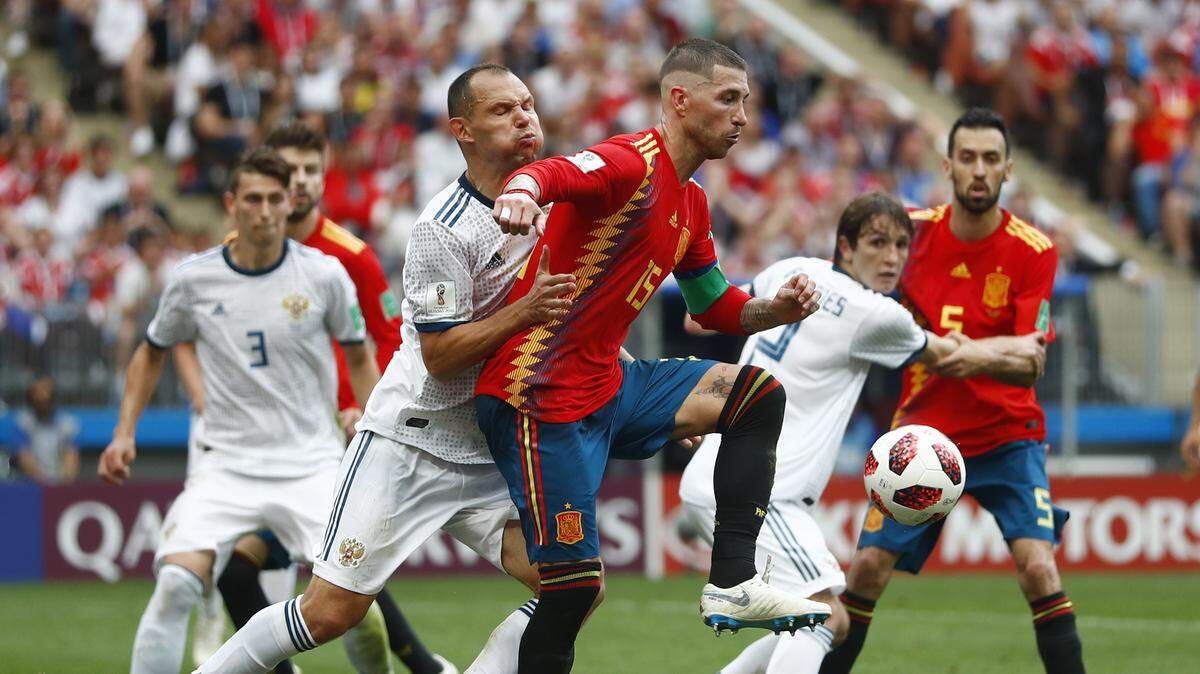 Sergio Ramos (centro) trata de superar a un jugador de Rusia en el partido efectuado el 1ro de julio de 2018 en Moscú, Rusia.
