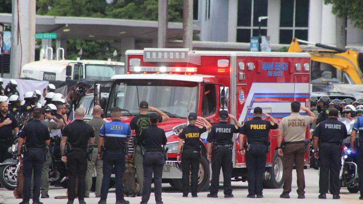 Agentes de distintas fuerzas del orden del sur de Florida saludan a la ambulancia que transporta el cuerpo del oficial de la Policía de Miami Beach David Cajuso, frente al Centro de Traumatología Ryder del Hospital Jackson Memorial, el martes 28 de octubre de 2025. Cajuso murió a causa de las heridas sufridas en un accidente de motocicleta ocurrido horas antes en la autopista I-75. Devoun Cetoute — dcetoute@miamiherald.com