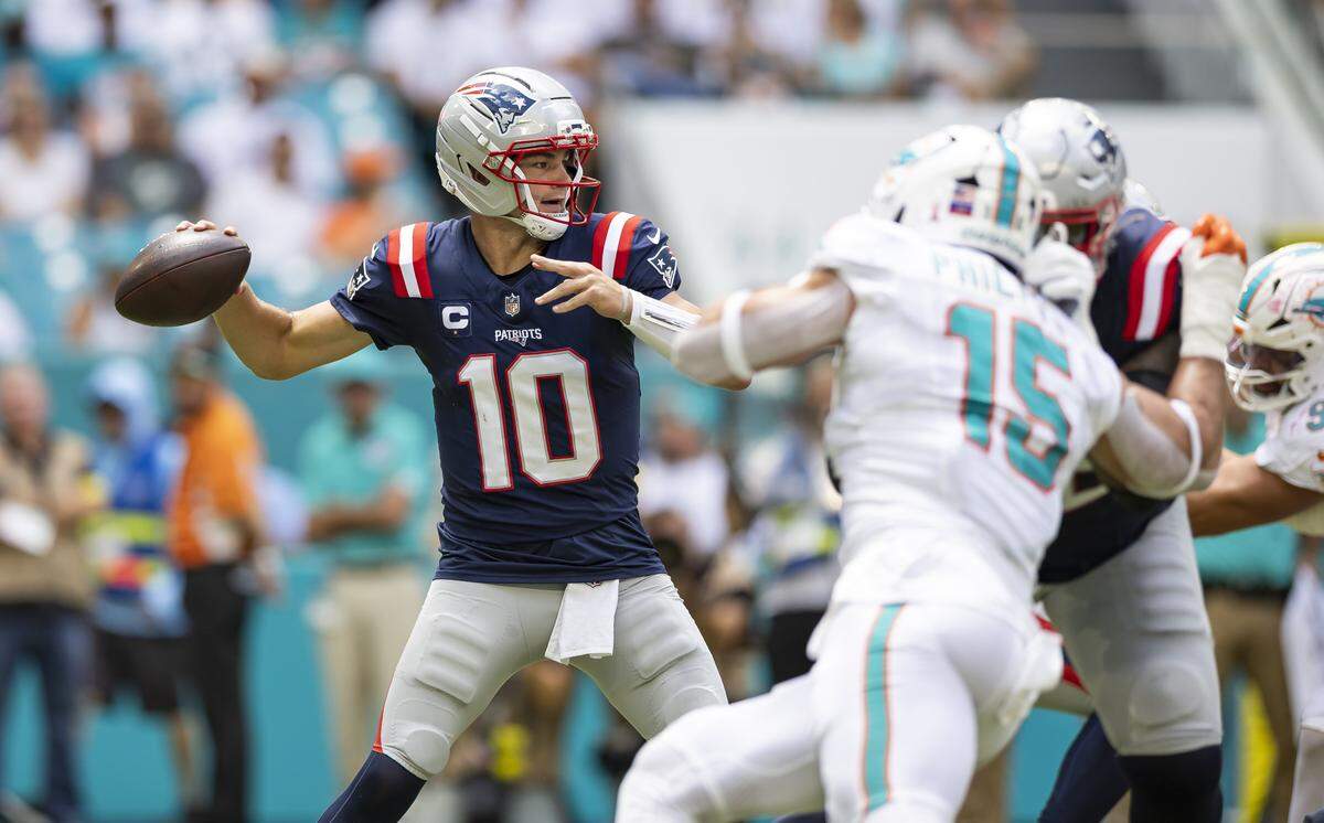 El quarterback de los Patriots de New England Drake Maye pasa el ovoide ante la marca del linebacker de los Dolphins Jaelan Phillips, en la primera mitad del partido celebrado el 14 de septiembre de 2025 en el Hard Rock Stadium en Miami Gardens, Florida.