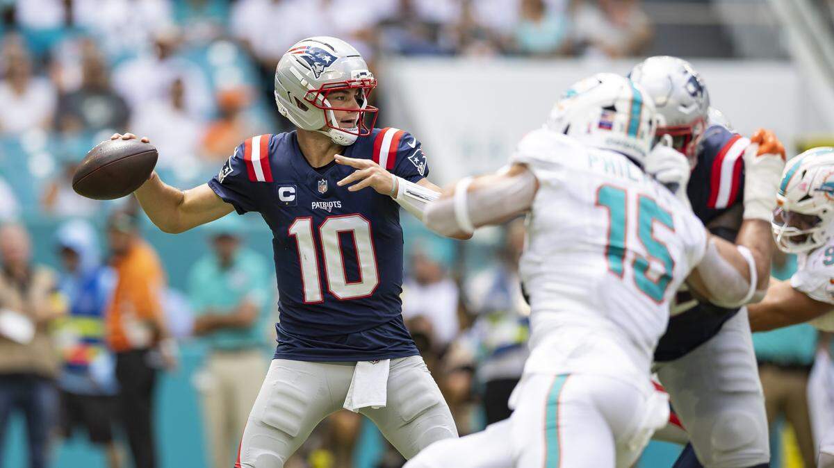 El quarterback de los Patriots de New England Drake Maye pasa el ovoide ante la marca del linebacker de los Dolphins Jaelan Phillips, en la primera mitad del partido celebrado el 14 de septiembre de 2025 en el Hard Rock Stadium en Miami Gardens, Florida.