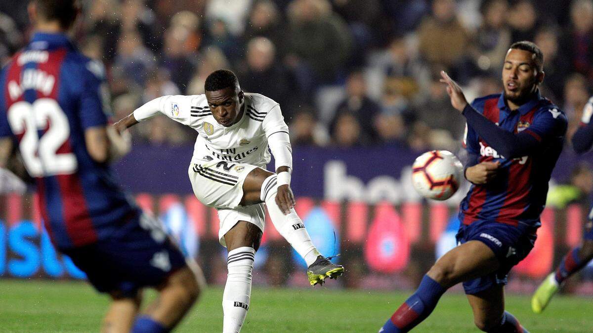 El delantero brasileño del Real Madrid, Vinicius Jr. (centro) golpea el balón ante los jugadores del Levante durante el encuentro celebrado el 24 de febrero de 2019.