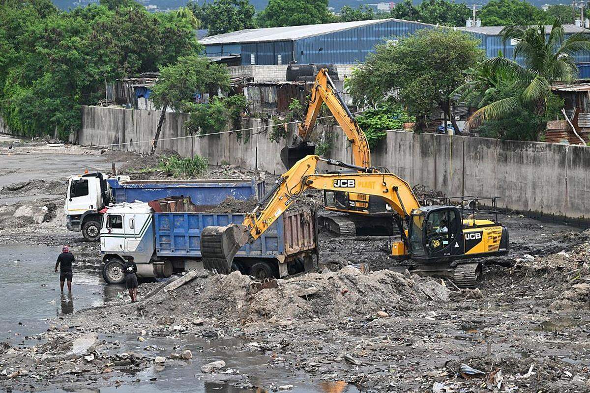 Crews clean the Sandy Gully, the main diversion channel for floodwaters in preparation for the arrival of Hurricane Melissa, just off Spanish Town road, in Kingston, Jamaica, on October 25, 2025. Deadly storm Melissa strengthened Saturday afternoon into a Category 1 hurricane, with rapid intensification expected over the weekend as it cut a worryingly slow course toward the Caribbean island of Jamaica, forecasters said. (Photo by Ricardo Makyn / AFP) (Photo by RICARDO MAKYN/AFP via Getty Images)