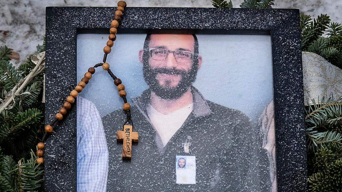 Un rosario adorna una fotografía enmarcada de Alex Pretti que fue colocada en un monumento improvisado en el lugar donde Pretti fue asesinado a tiros un día antes por agentes federales de inmigración en Minneapolis, Minnesota, el domingo 25 de enero de 2026.His killing sparked new protests and impassioned demands by local leaders for the Trump administration to end its operation in the city. (Photo by ROBERTO SCHMIDT / AFP via Getty Images)