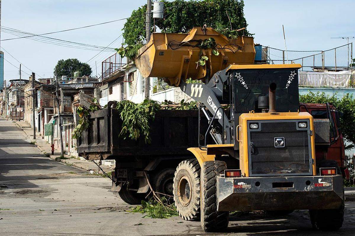 A tractor loads pruned tree branches onto a truck ahead of the arrival of Tropical Storm Melissa in Santiago de Cuba on October 25, 2025. Cuba has begun preparations to face the impact of Tropical Storm Melissa in at least two provinces in the central and eastern parts of the island, as the storm moves toward Jamaica. (Photo by AFP) (Photo by STRINGER/AFP via Getty Images)