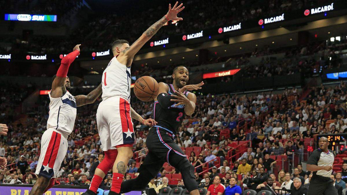 El jugador del Heat Wayne Ellington (der.) pasa la pelota ante la defensa de los Wizards, en el partido efectuado el 10 de noviembre de 2018 en Miami.