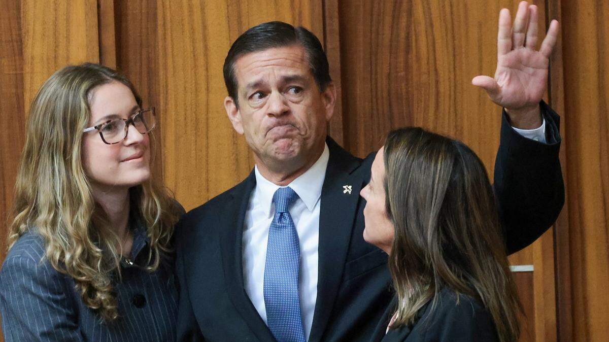 Acompañado por su hija, Carolina Pino (izquierda), y su esposa, Cecilia Pino (derecha), el corredor de bienes raíces George Pino saluda a sus simpatizantes a su llegada a la Sala 4-1 para su entrega en el Edificio de Justicia Richard E. Gerstein el jueves 21 de noviembre de 2024 en Miami, Florida.