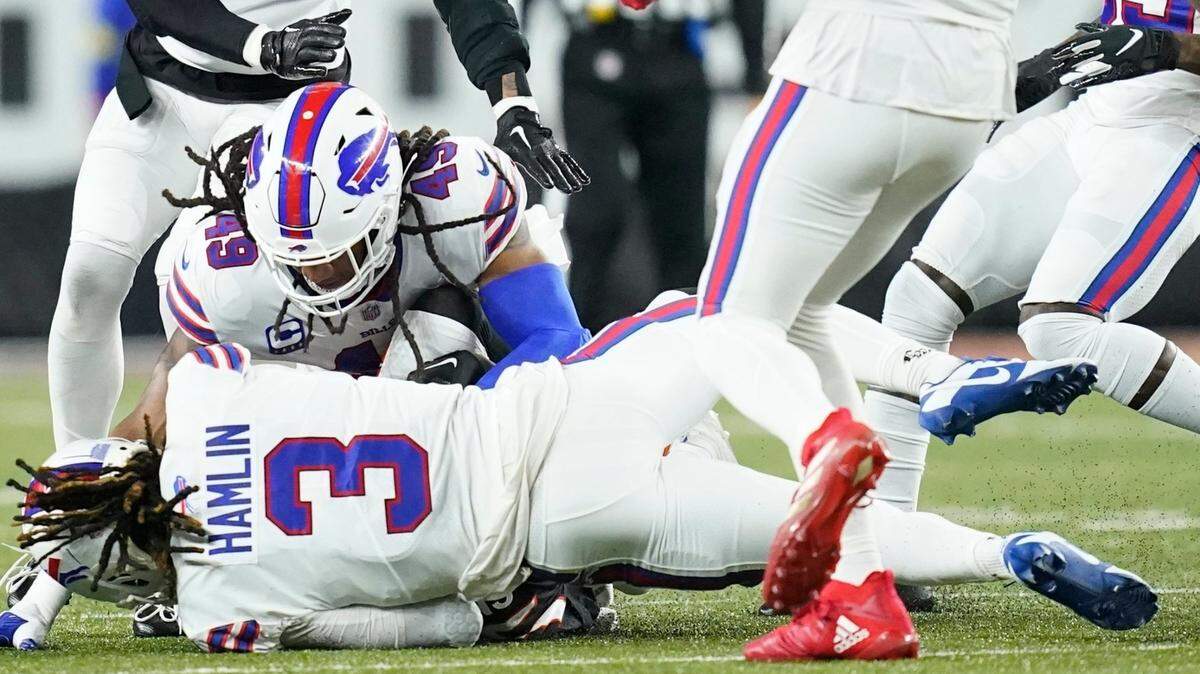 El safety de los Buffalo Bills Damar Hamlin yace en el suelo mientras su compañero de equipo, el linebacker Tremaine Edmunds, trata de ayudarlo a reponerse en el partido ante los Bengals, el 2 de enero de 2023 en Cincinnati.
