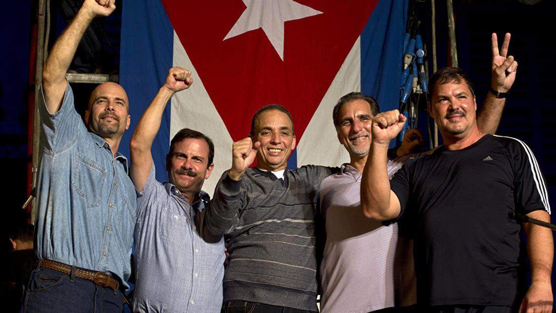Los cinco espías cubanos posan para una foto junto a la bandera en La Habana.