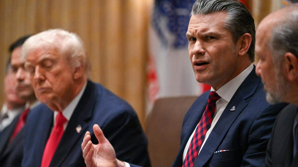 US Secretary of Defense Pete Hegseth (R) speaks alongside President Donald Trump (L) during a Cabinet Meeting in the Cabinet Room of the White House in Washington, DC on December 2, 2025. (Photo by ANDREW CABALLERO-REYNOLDS / AFP via Getty Images)