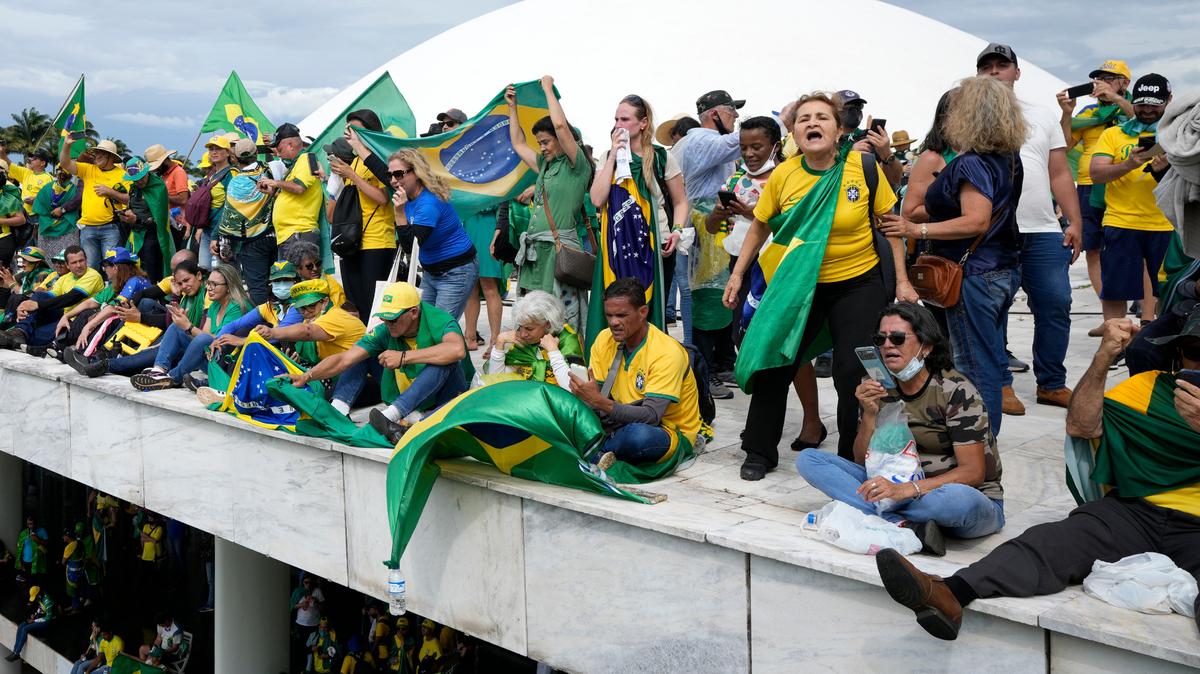 Manifestantes, simpatizantes del expresidente brasileño Jair Bolsonaro, se paran en el techo del edificio del Congreso Nacional después de que lo asaltaron, en Brasilia, Brasil, el domingo 8 de enero de 2023.